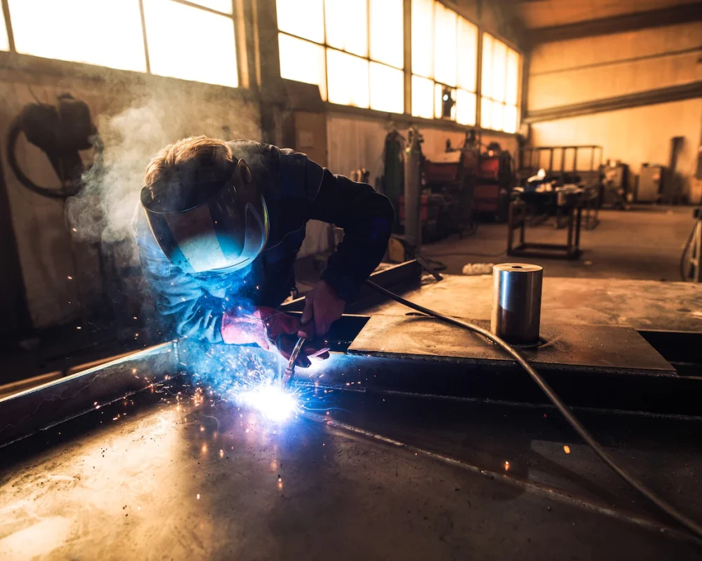 professional-welder-protective-uniform-helmet-welding-metal-part-workshop_342744-518